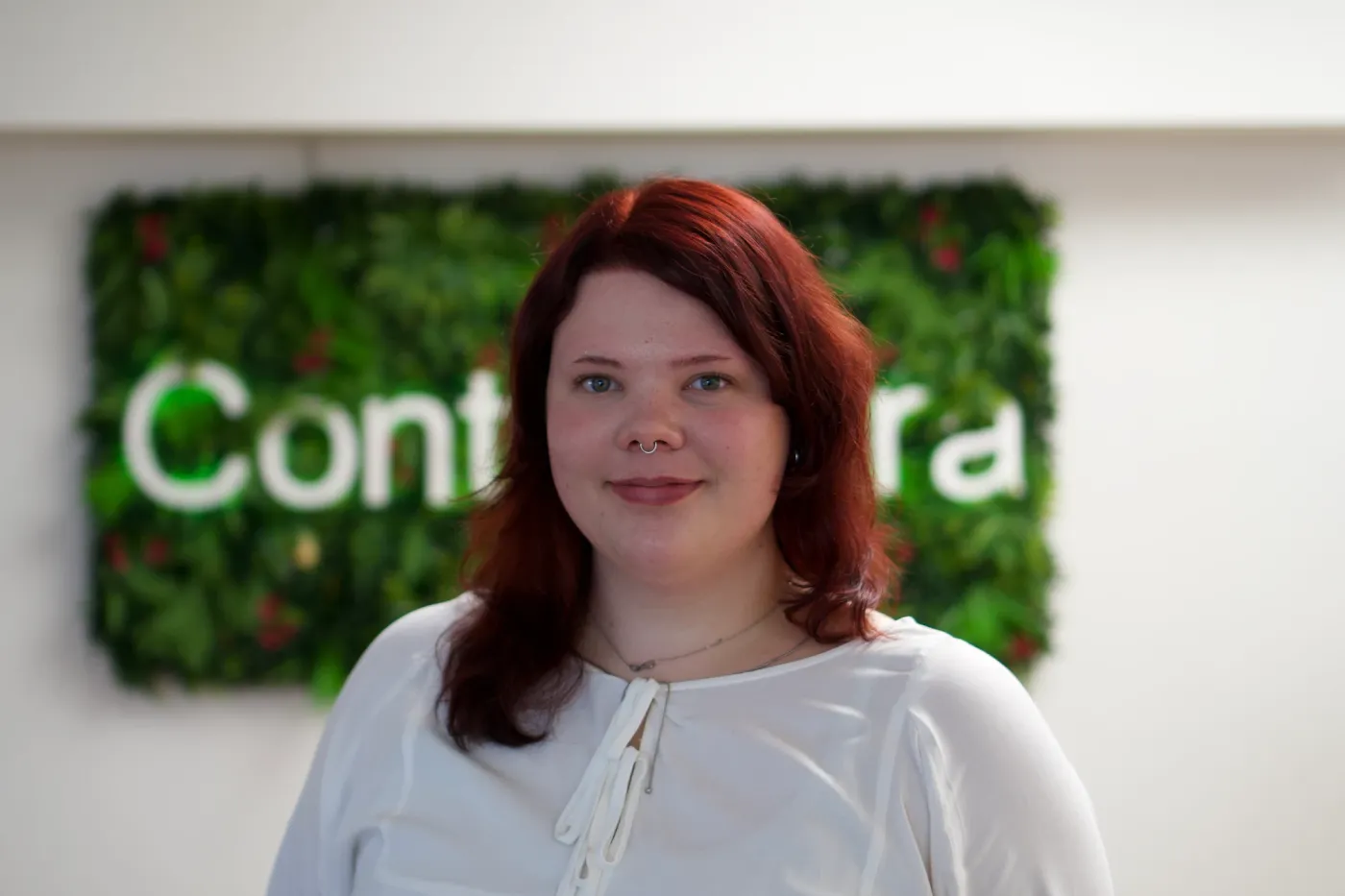 Fiona Voigt vor der begrünten Wand mit dem Contentura-Schriftzug