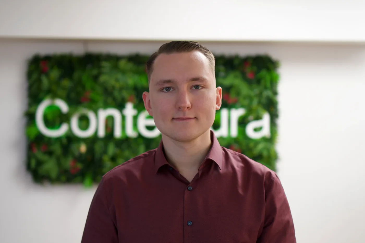 Sebastian Berndt vor der begrünten Wand mit dem Contentura-Schriftzug